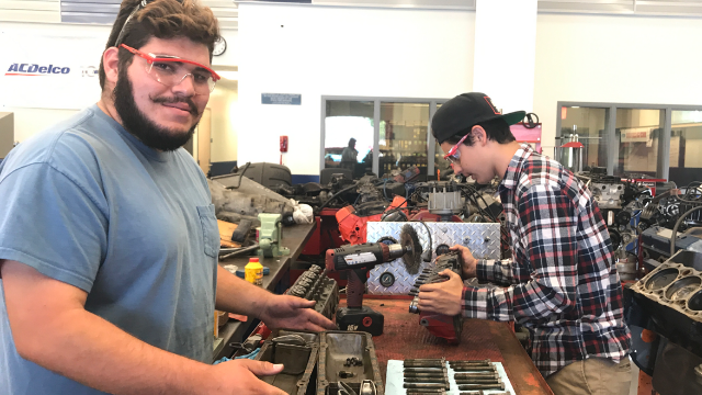 Students working on a car engine