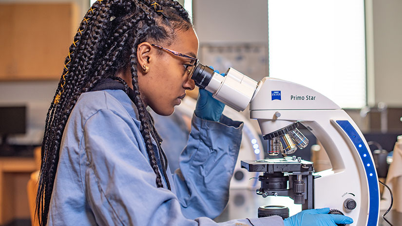 Student looking into microscope 