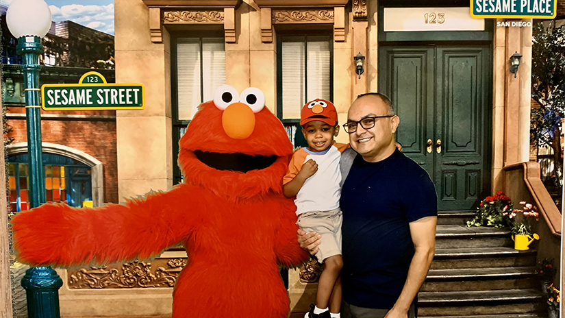 Nick and his son Nico posing with Elmo