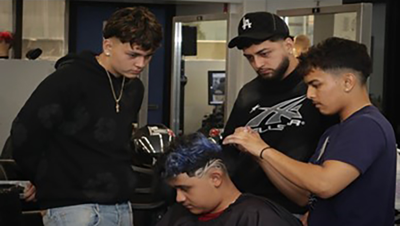 Student Randy Bonilla working alongside teammates during the Barber Battle
