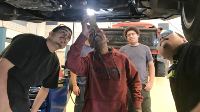Automotive technology students working on a car